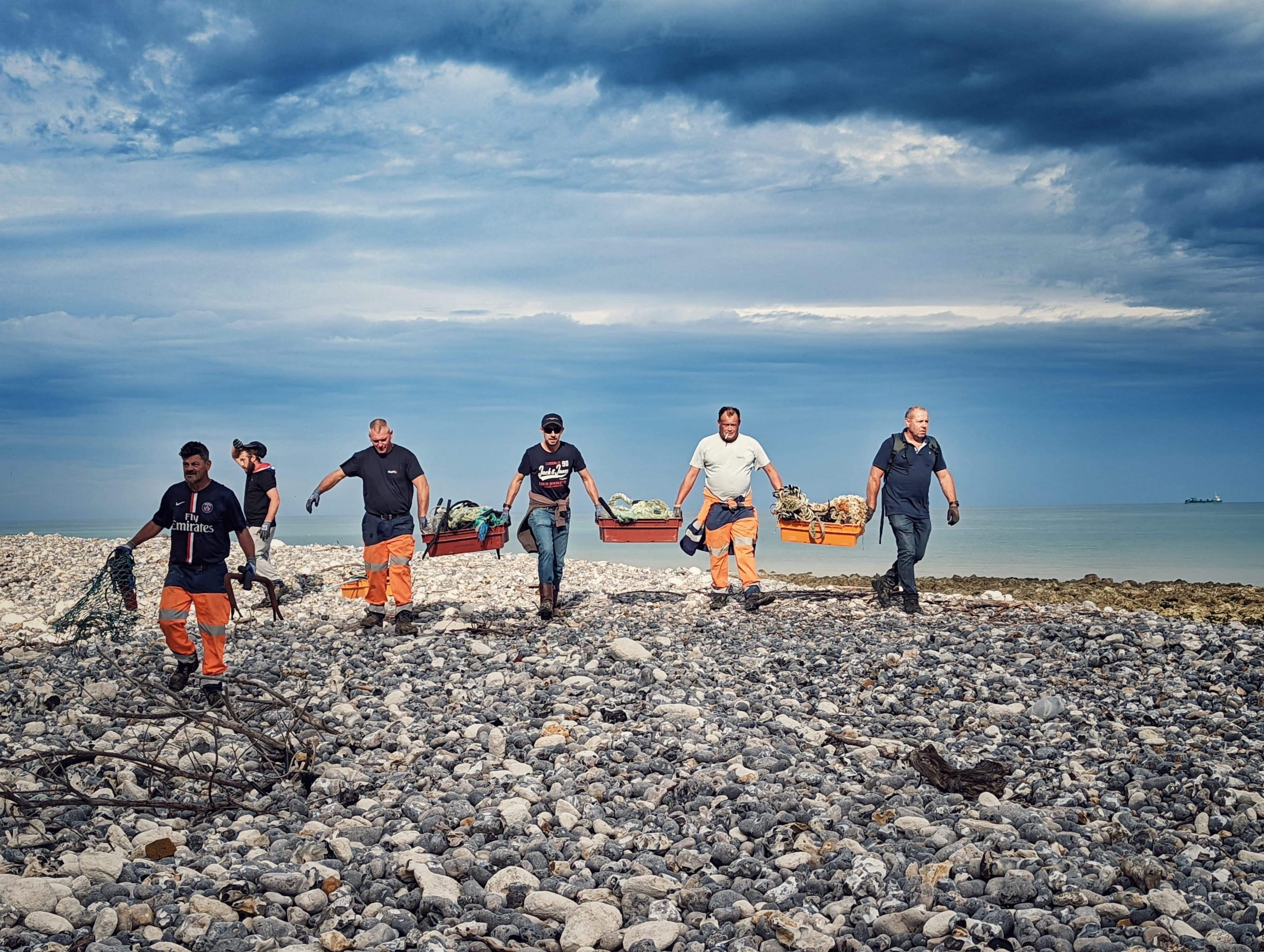 hommes qui nettoient les déchets sur une plage